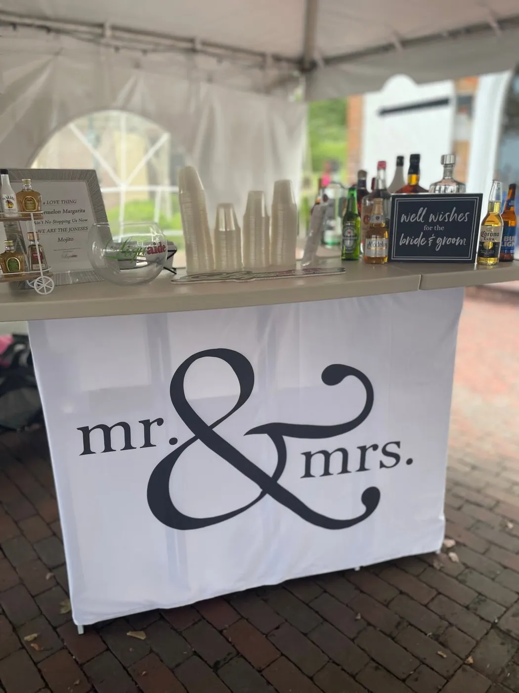 Liquaide mobile bar dressed for a wedding reception with a "mr. & mrs." skirt and well-wishes sign
